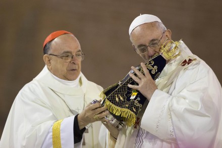 The Pope kisses an idol of stone wood. 