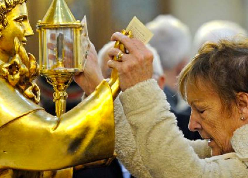 A British woman hold hands with a golden statues, and pray to a piece of rotten human flesh. 