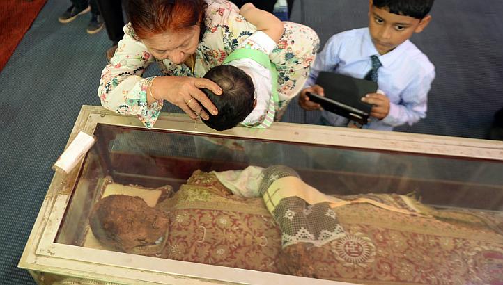Even small children are forces to kiss the glass box wich contains the 500 year old corpse. 