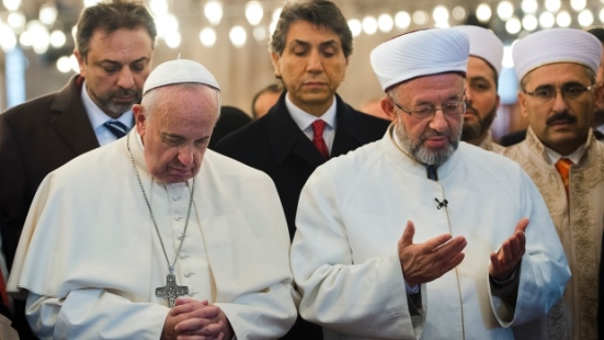 The Pope deeply into prayers towards Mecca, visiting a mosque in Istanbul. 