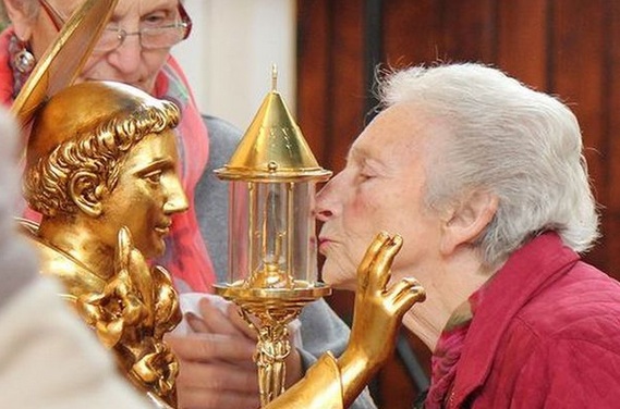 A devouted Roman Catholic kiss the container holding a 750 year old tooth. 